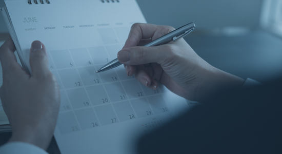 person writing on calendar