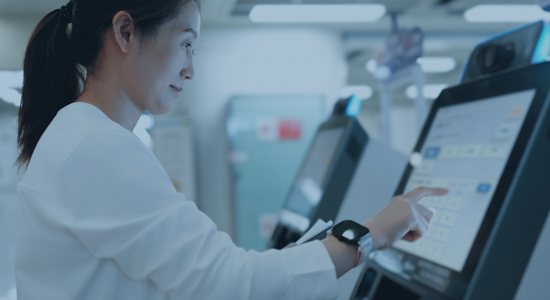Woman using self-service computer kiosk