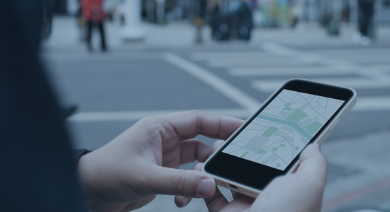 Persons hands holding a phone displaying a map.